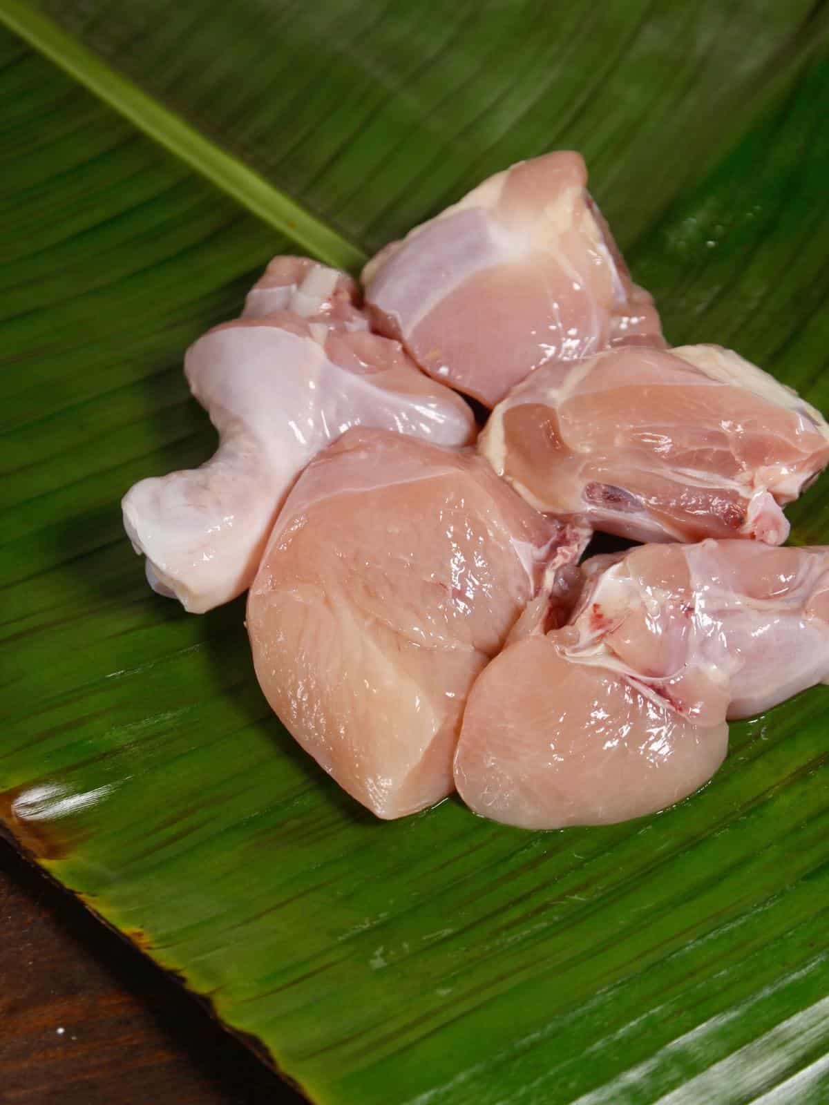 Fresh chicken cuts served on a banana leaf